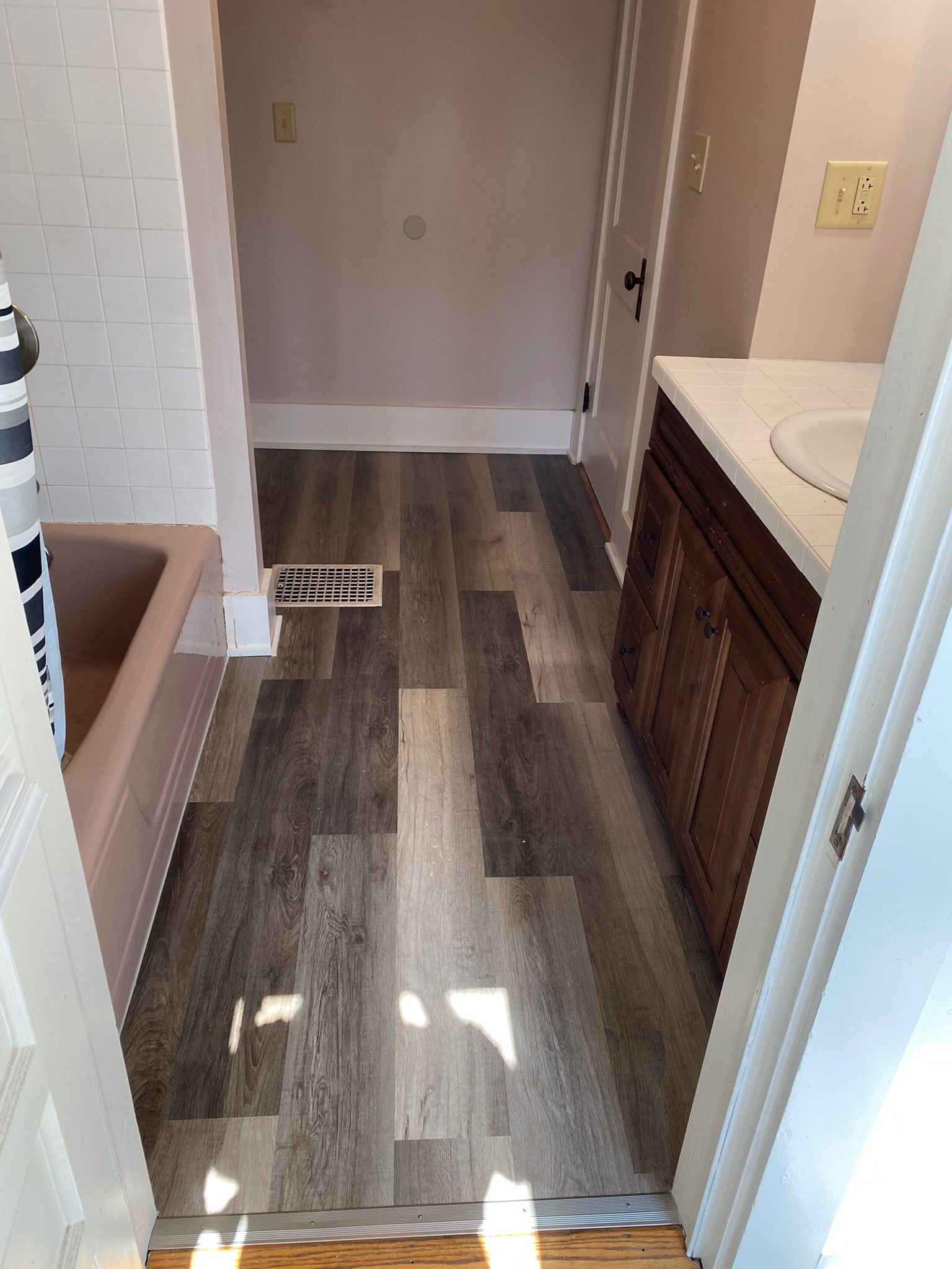 Bathroom flooring installation with luxury vinyl plank and custom vanity