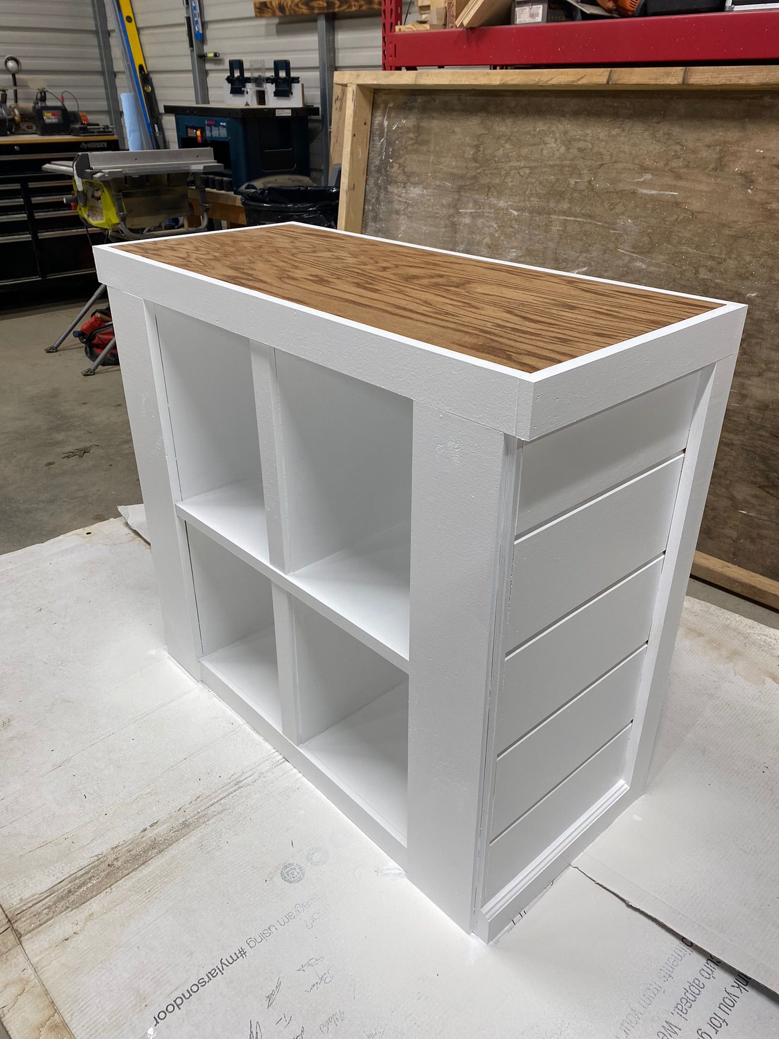 Custom white cabinet with wood countertop being crafted in workshop