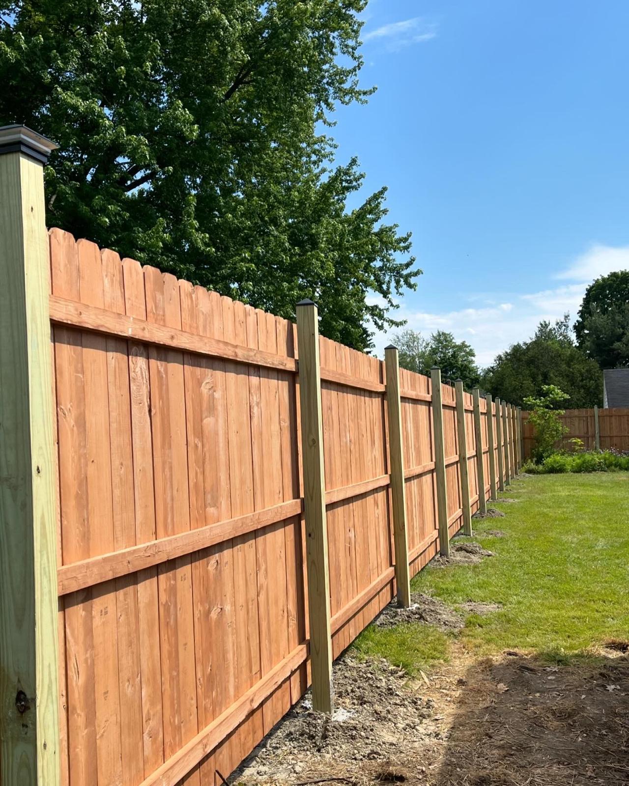 Long section of custom wooden fence with horizontal support rails