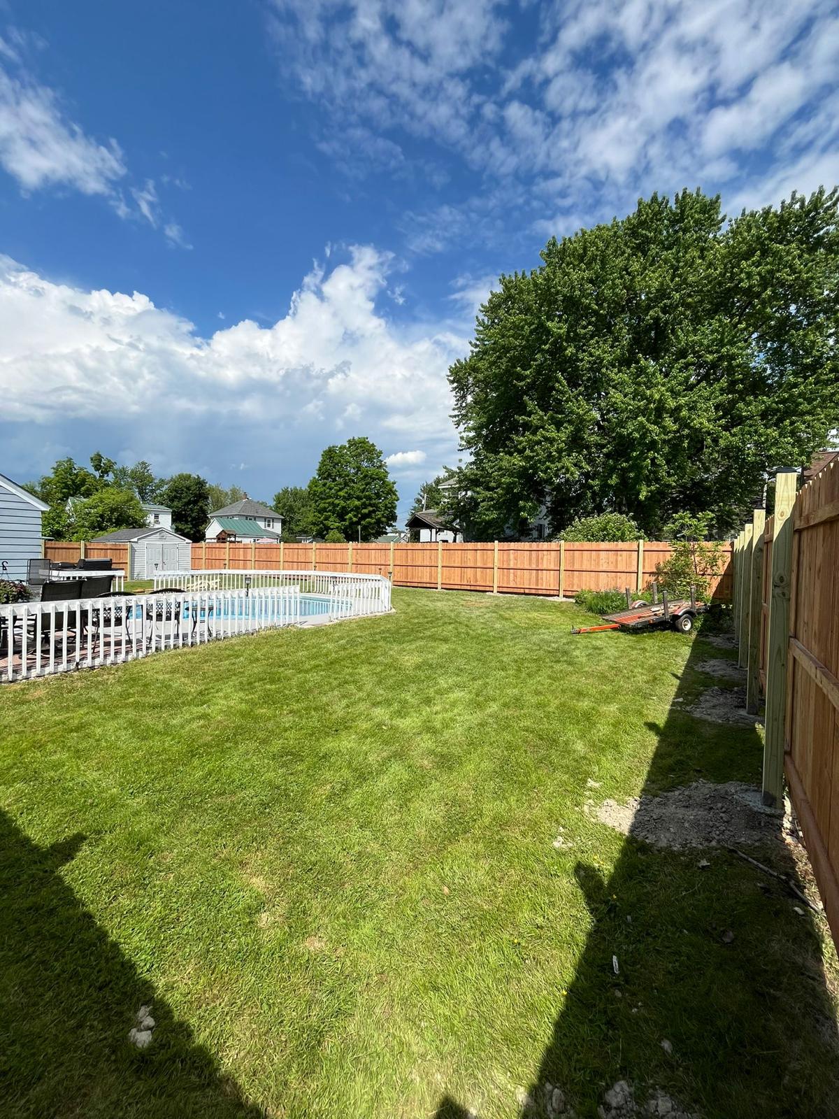 Wooden fence enclosing backyard pool area with gate access