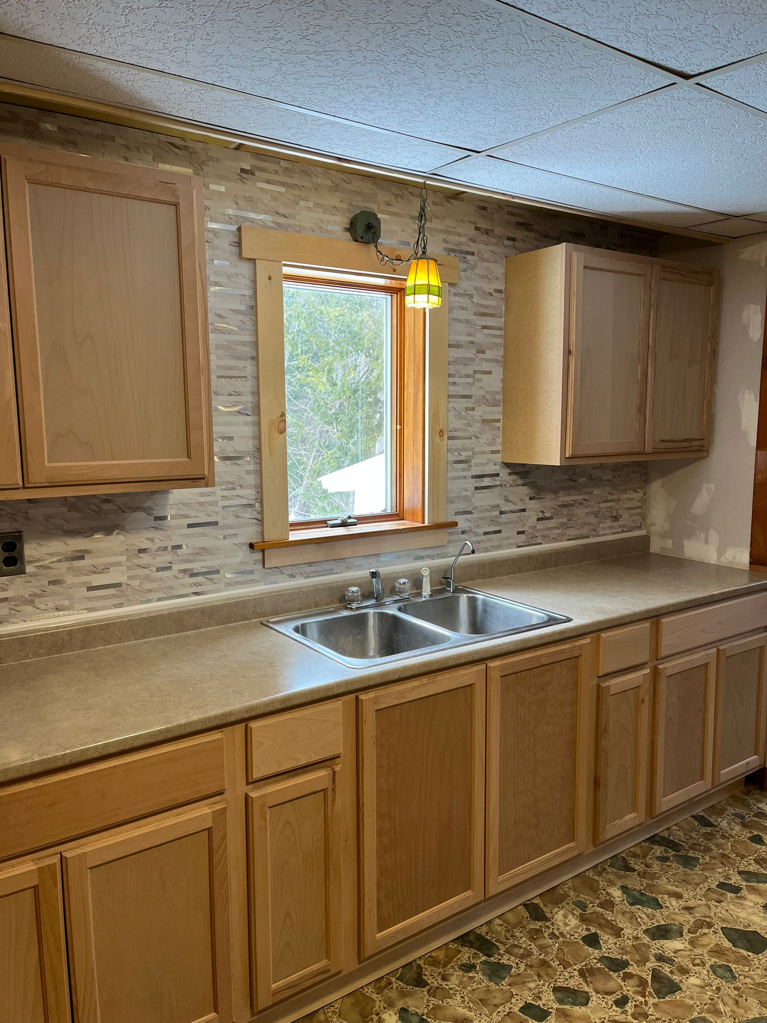 After - Renovated kitchen with stone backsplash and updated cabinets