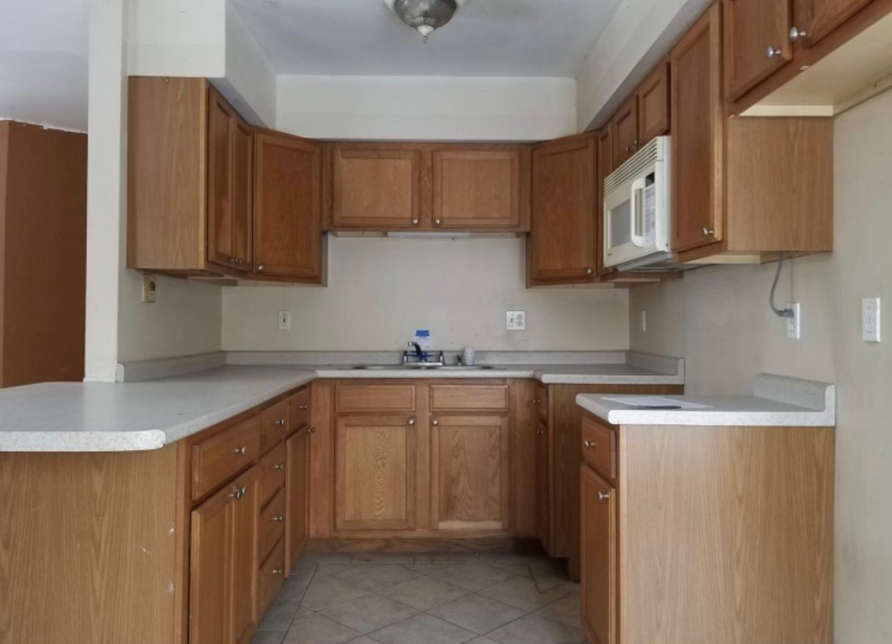 Before - Traditional kitchen with basic cabinetry and standard appliances