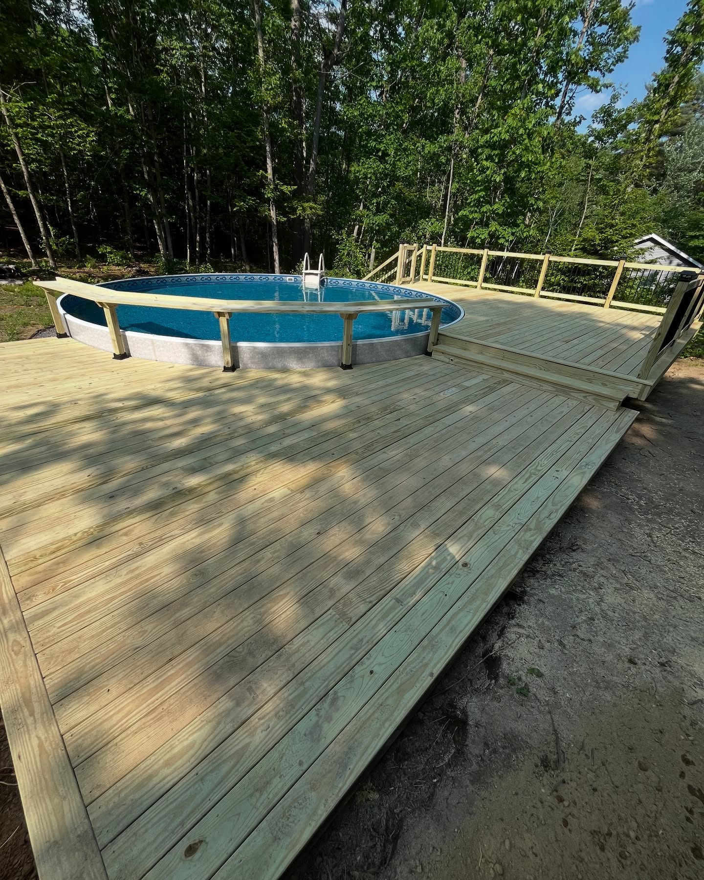 Custom wooden pool deck with railings and multi-level design