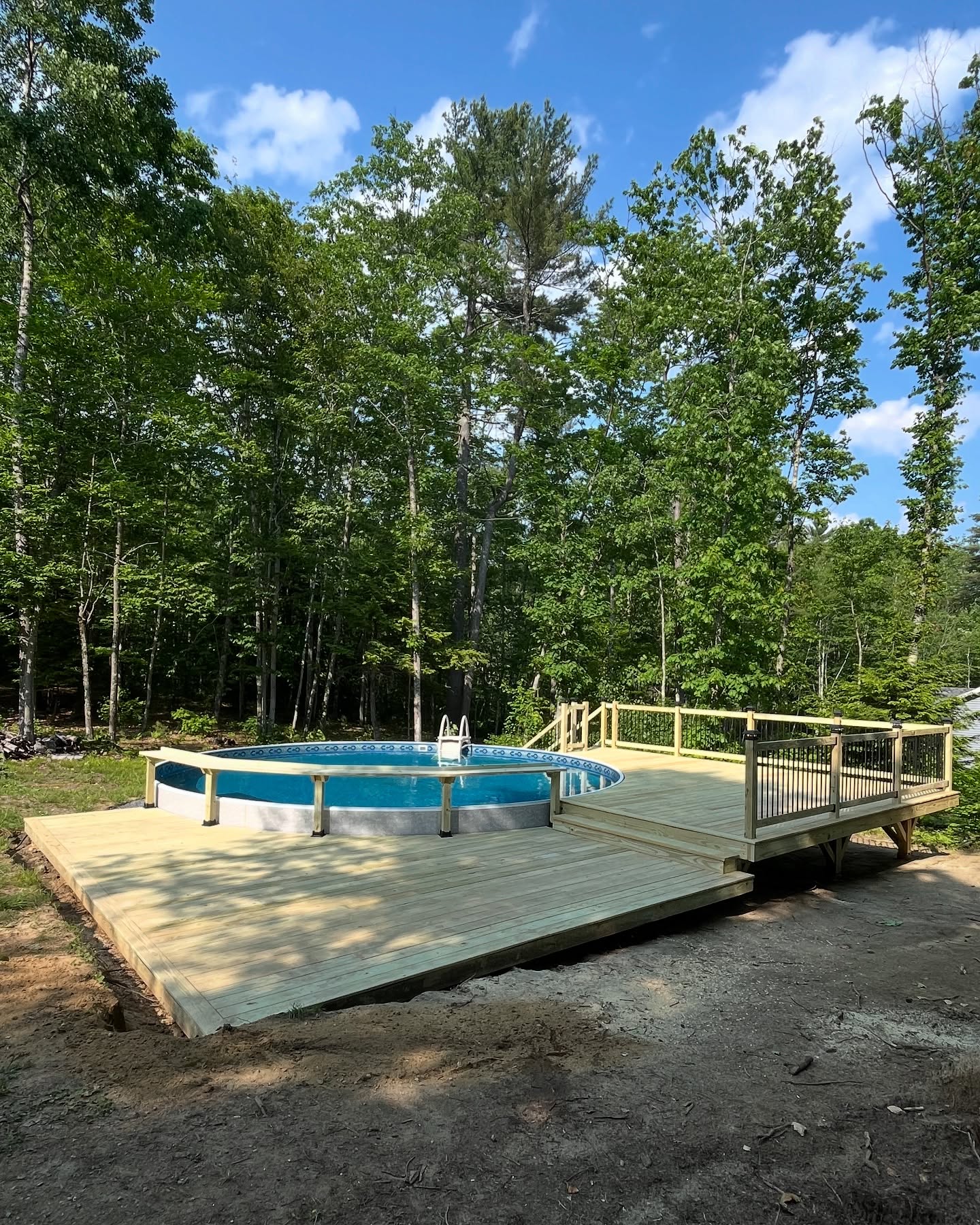 Large wooden deck platform surrounding pool with professional construction