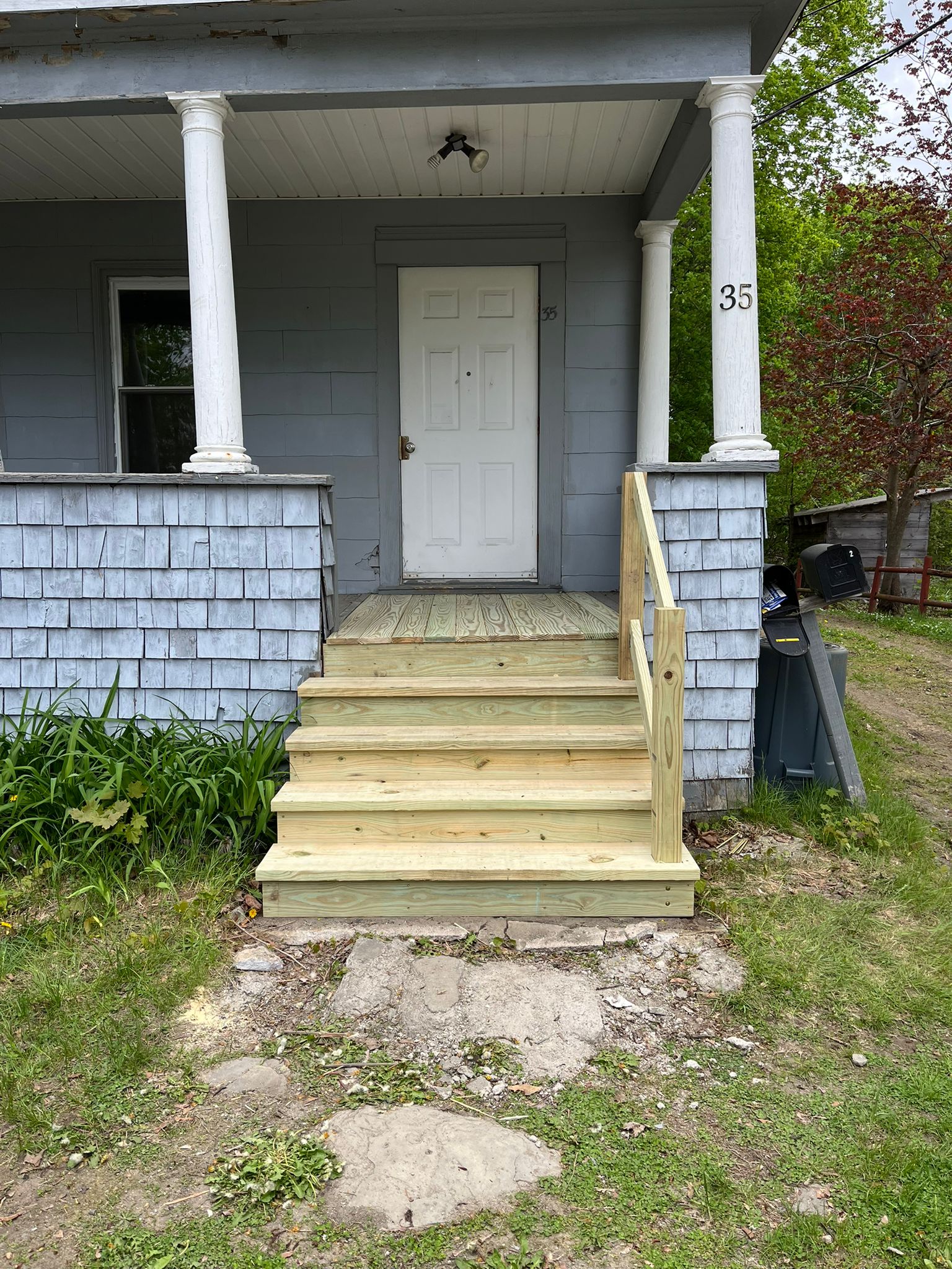After - Beautiful new wooden porch steps with fresh railing